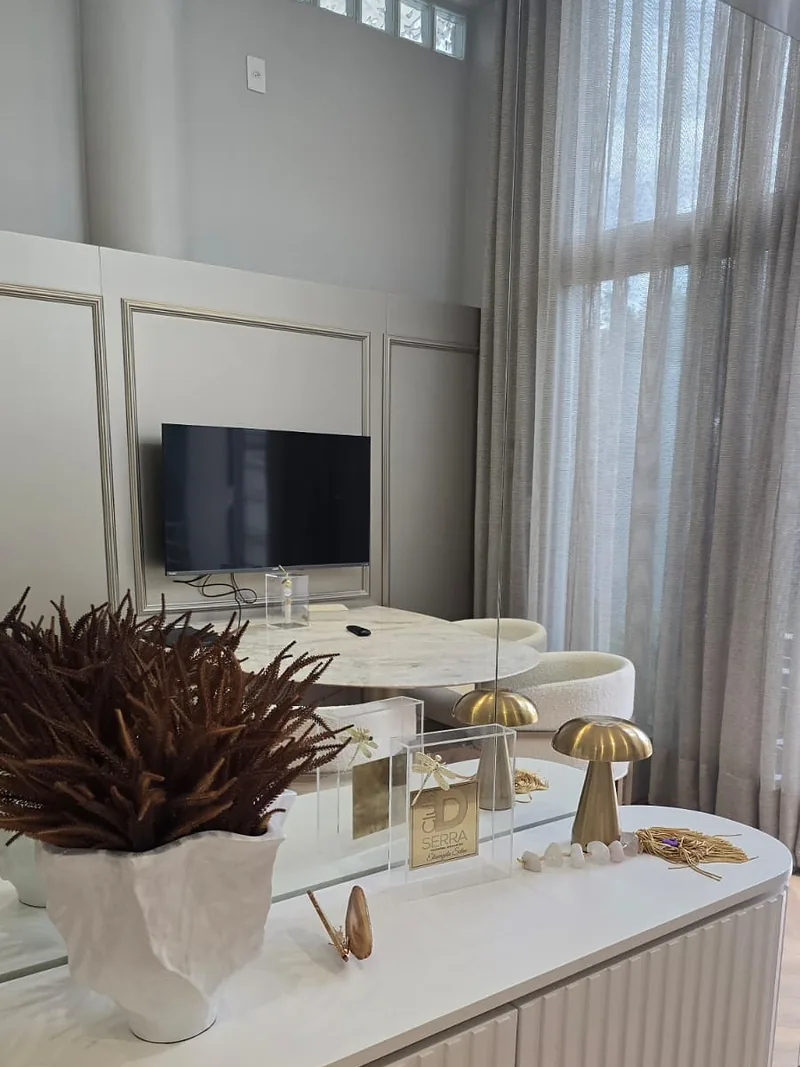 Buffet em marcenaria ripada com espelho, luminárias de mesa e objetos de decoração.